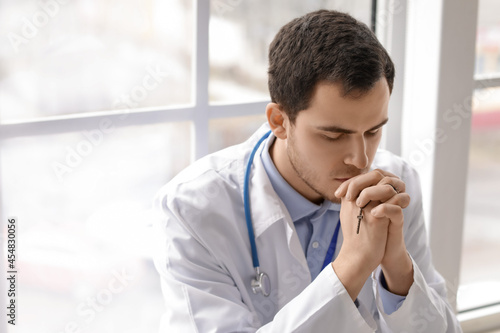 Religious doctor praying in...