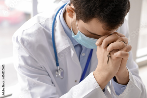 Religious doctor praying in...