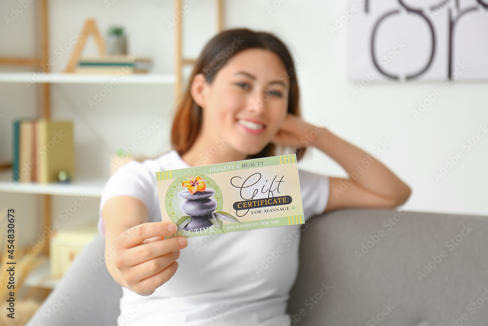 Young Asian woman with gift certificate for massage at home Young Asian woman with gift certificate for massage at home