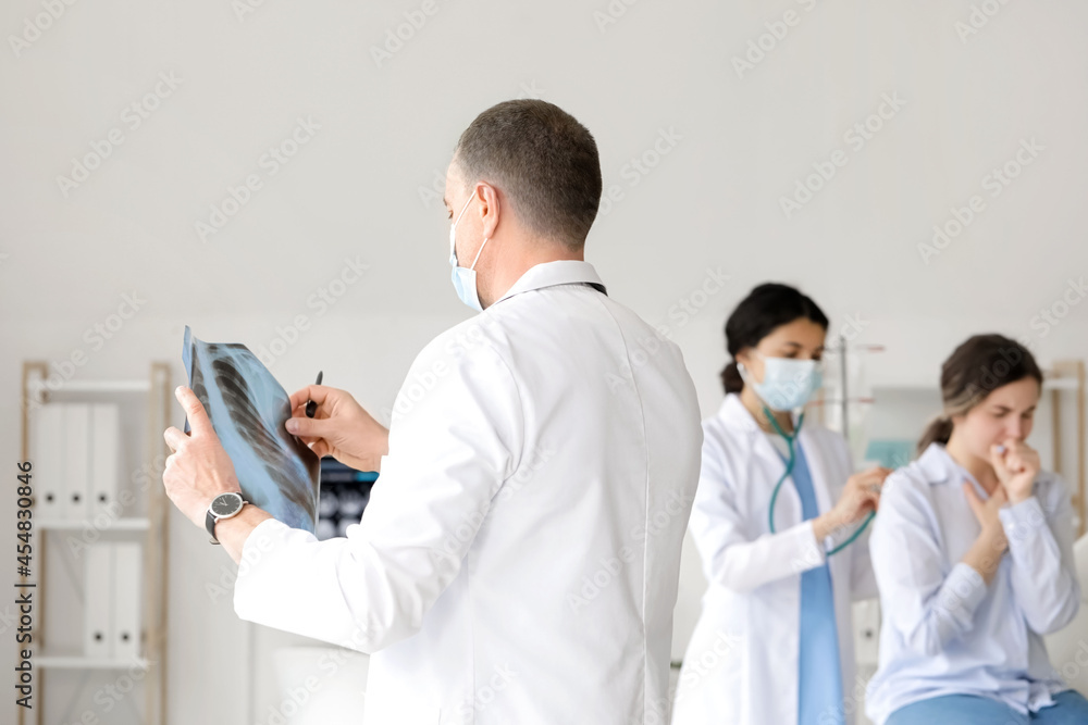 Mature doctor studying x-ray image of lungs in clinic Mature doctor studying x-ray image of lungs in clinic
