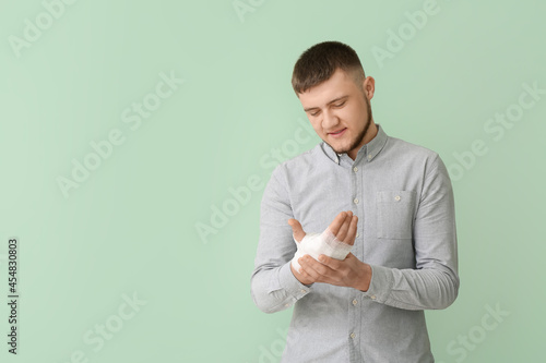 Young man with bandaged han...