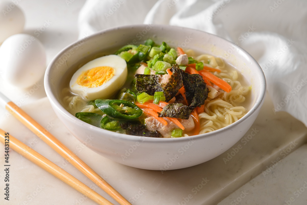 Tasty Chinese soup with chicken in bowl on light background