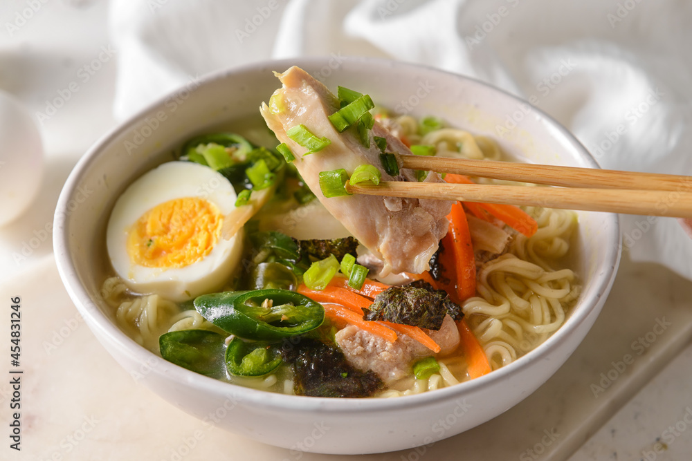 Tasty Chinese soup with chicken in bowl on light background, closeup Tasty Chinese soup with chicken in bowl on light background, closeup