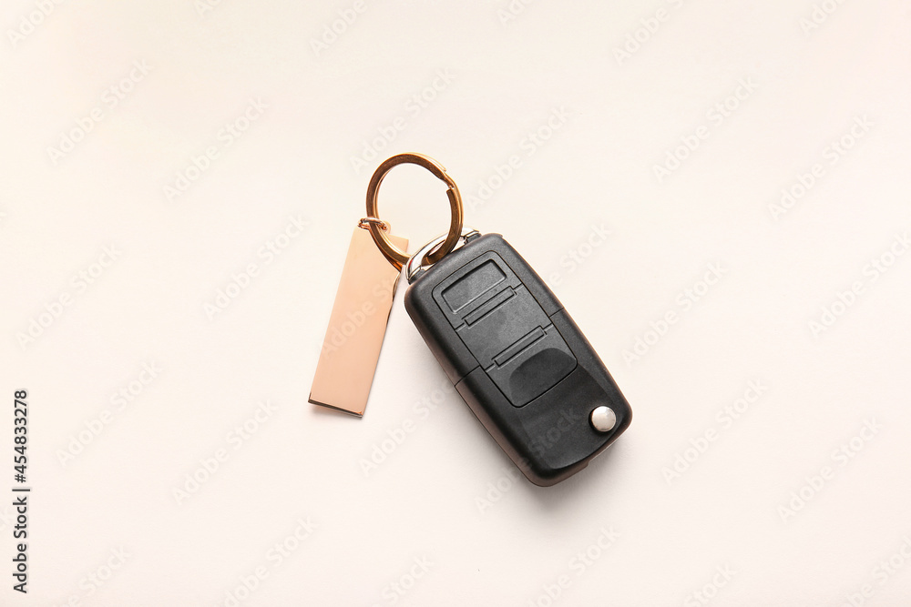 Car key with stylish keychain on light background Car key with stylish keychain on light background