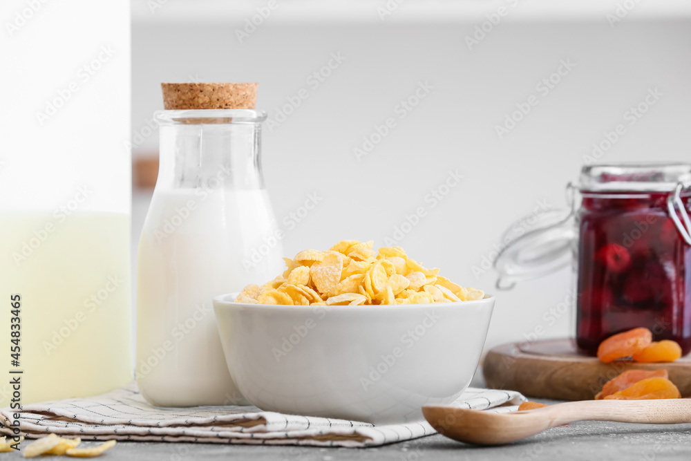 Bowl with tasty corn flakes and bottle of milk on table in kitchen Bowl with tasty corn flakes and bottle of milk on table in kitchen