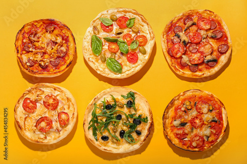 Tasty mini pizzas on color background