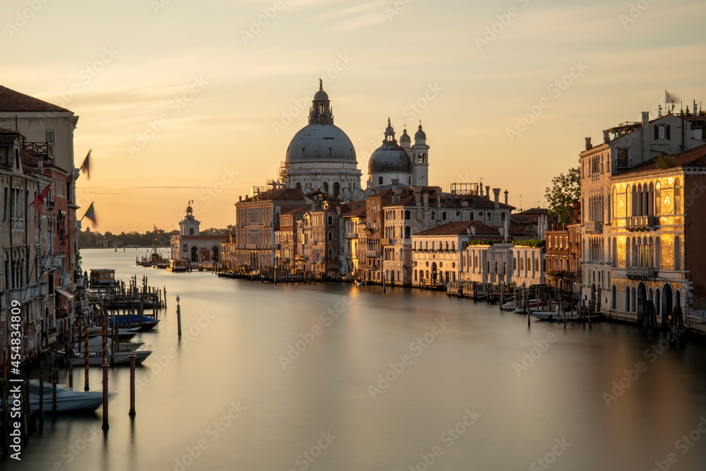 Venice, Italy. Sunrise view of the Grand Canal and Basilica Santa Maria della Salute. Focus on basilica, boats slightly blurred by long exposure.