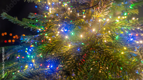 Close-up image of illuminated christmass trees with garland. Lights and balls on defocused background. Christmas concepts. Xmas background. Space for text.