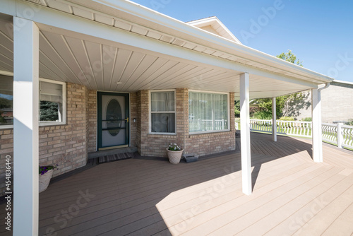 Wooden veranda of a house with screen door and white main door photo