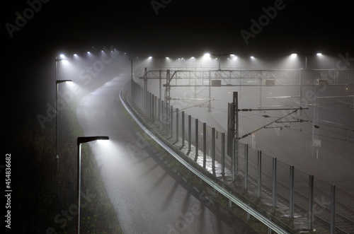Foggy night and lights with fenced in railway lines in Norway