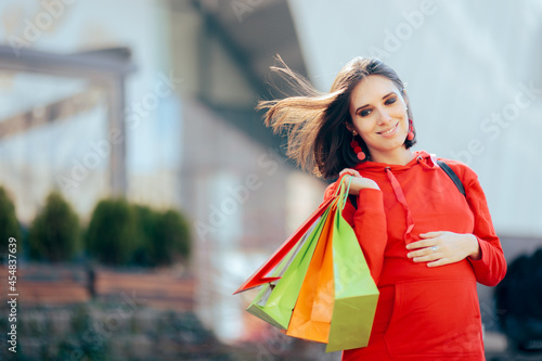 Pregnant Woman Touching Baby Bump Holding Shopping Bags