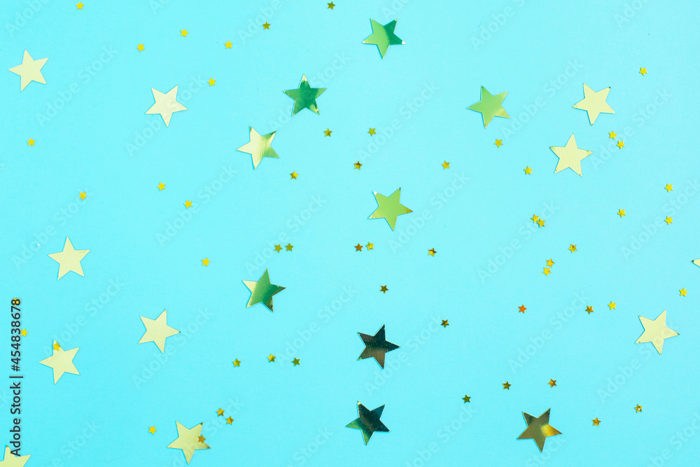 Gold glitter stars decorations on blue background.