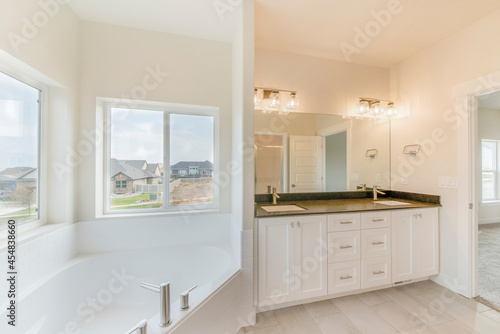 Contemporary masters bathroom with sliding windows in all white