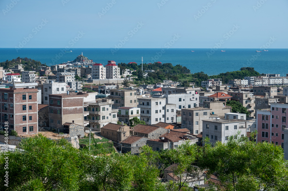 The seaside town with many buildings has beautiful scenery under the blue sky