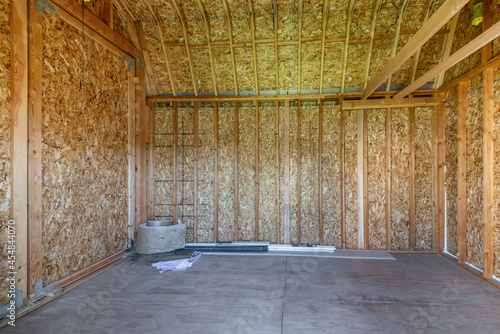 Interior of an empty shed with wood frameworks and concrete flooring