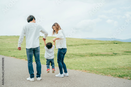 手を繋いで歩く家族（後ろ姿）  © buritora