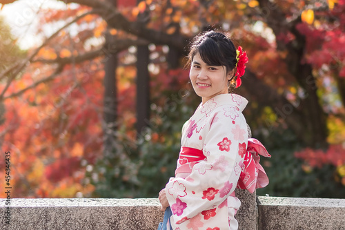 young woman tourist wearing kimono enjoying with colorful leaves in temple, Kyoto, Japan. Asian girl with hair style in traditional Japanese clothes in Autumn foliage season