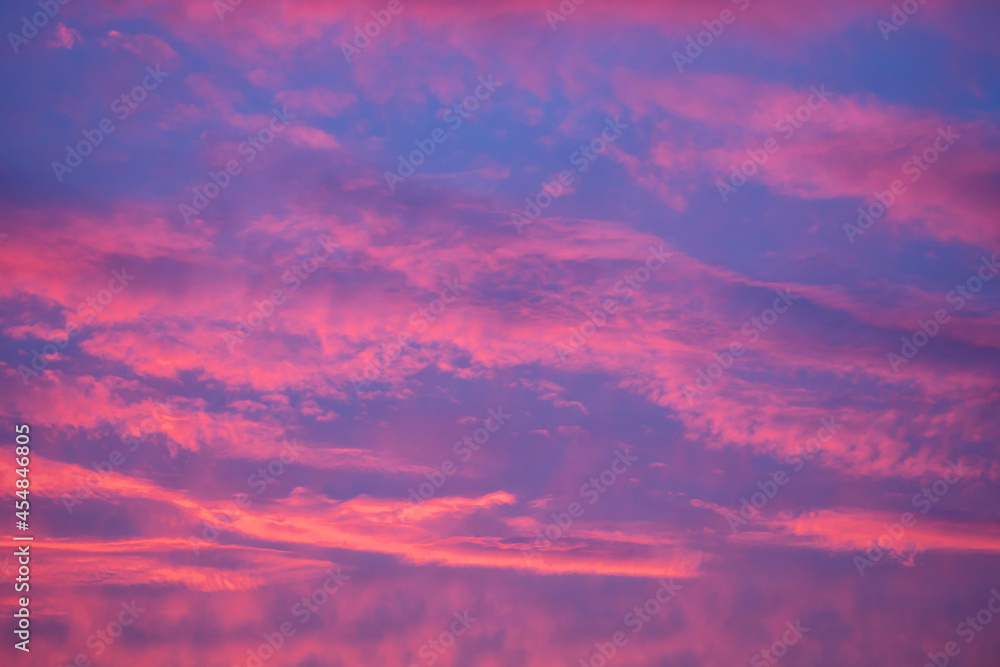 Red clouds against a blue sky. Colorful sunset. Abstract background for wallpaper.