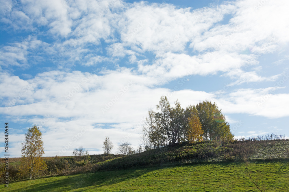 秋の青空と緑の丘
