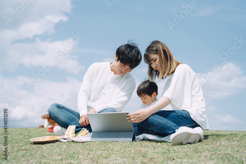 空とタブレットPCを使う家族
