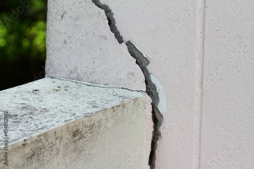 Pink cement wall background cracked and peeling paint.