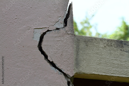 Pink cement wall background cracked and peeling paint.