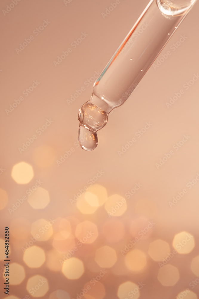 A drop of cosmetic oil falls from the pipette A drop of cosmetic oil falls from the pipette