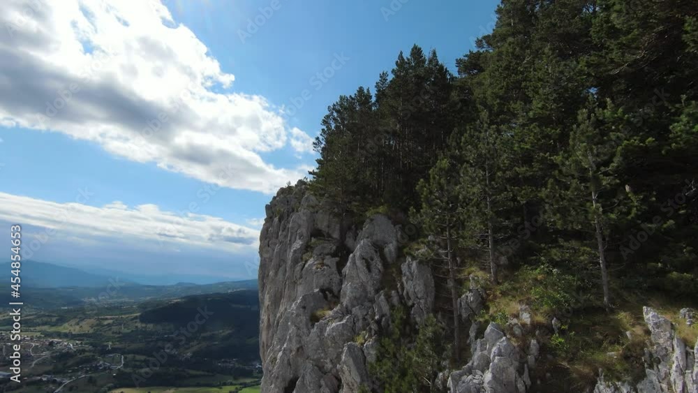 Aerial cinematic shot high speed sport fpv drone flying over natural mountain cliff surrounded Amazing nature rocky terrain with green vegetation and forest on cloudy day. Aerial cinematic shot high speed sport fpv drone flying over natural mountain cliff surrounded Amazing nature rocky terrain with green vegetation and forest on cloudy day.