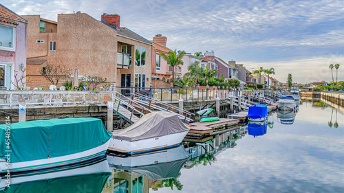 Pano Boats on docks of canal along seaside houses in Huntington Beach Califonia photo