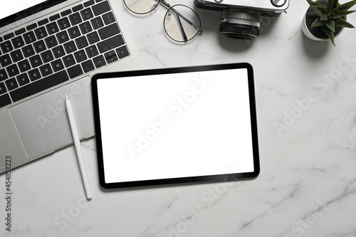 Top view digital tablet, stylus pen and laptop computer on marble background. photo