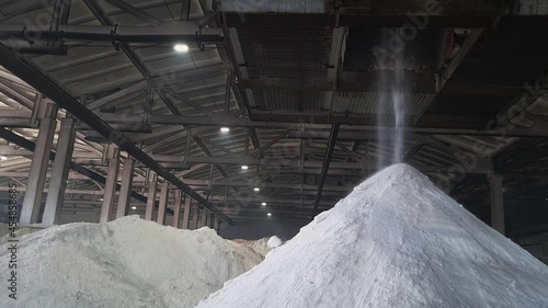 Ammonium sulfate powder pour in a pile inside a warehouse of chemical plant. Mineral organic fertilizers for agriculture industry.