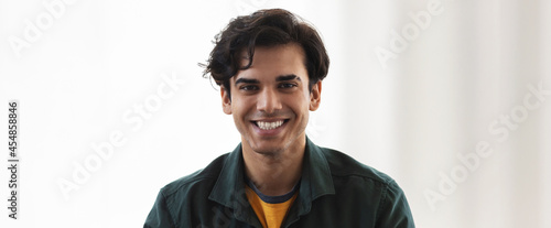 Portrait of happy caucasian young man looking at the camera and smiling
