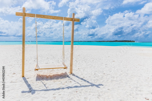 wooden swing on a white sand beach on the Indian Ocean in the Maldives