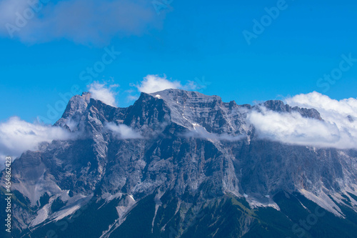 Zugspitze mountain massif disappearing in fog and clouds with dramatic sky. Copy space. Template for travel and tourism concept. © familie-eisenlohr.de