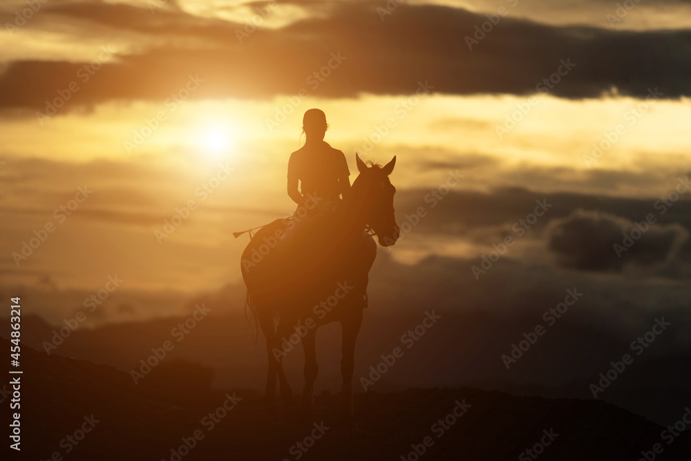 The silhouette of a woman riding a horse
