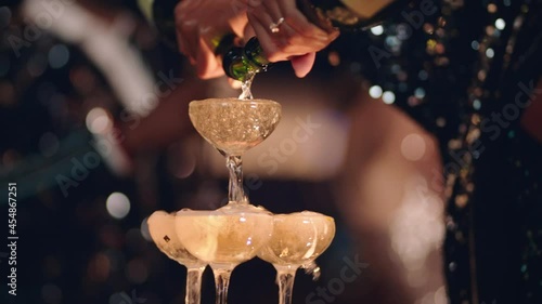 happy celebration woman pouring champagne tower at glamorous dance party celebrating with friends enjoying crazy nightlife wearing stylish fashion dancing on rooftop at night 4k footage photo