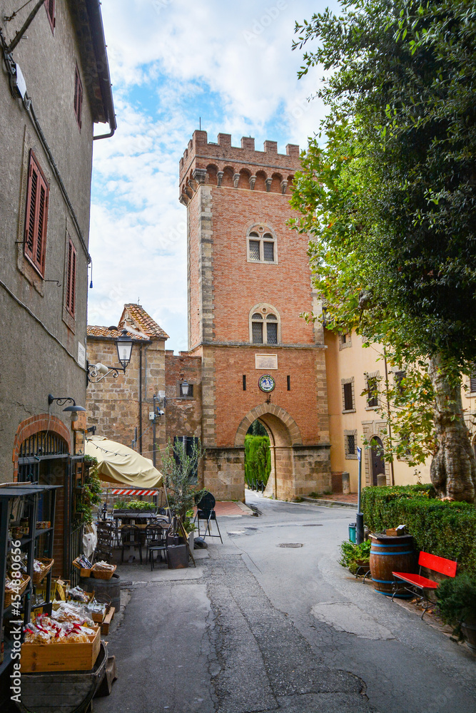 Blick auf das Eingangstor von Bolgheri in der Toskana. Bolgheri, ein schönes kleines Dorf in der Toskana. Der einzige Zugang ist ein Tor unterhalb eines Turmes. Blick auf den Eingang vom Zentrum aus
