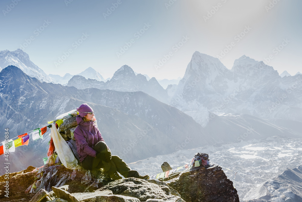 Woman Traveler with Backpack hiking in Mountains with beautiful Himalaya landscape on background. Mountaineering sport lifestyle concept