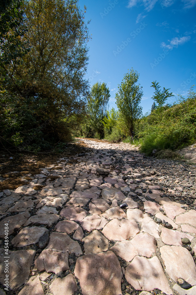 The riverbed without water, the drought takes its toll. The riverbedbed is paved with stones. The riverbed without water, the drought takes its toll. The riverbedbed is paved with stones.