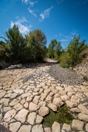 The riverbed without water, the drought takes its toll. The riverbedbed is paved with stones.