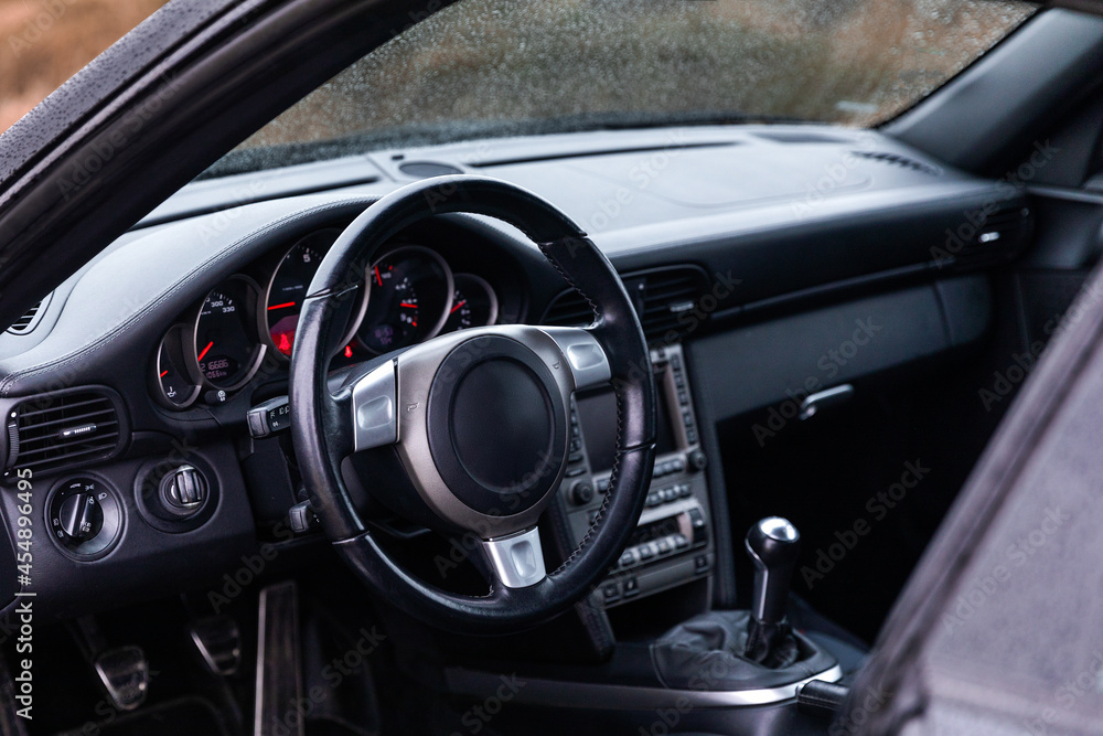 Driver's seat of the car. Sport car interior. Steering wheel, shift lever and dashboard