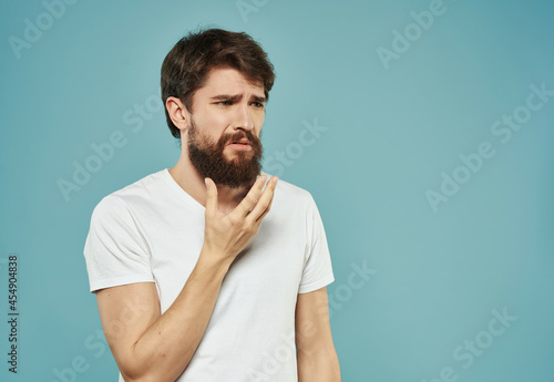 emotional man in a white t-shirt irritated facial expression Studio