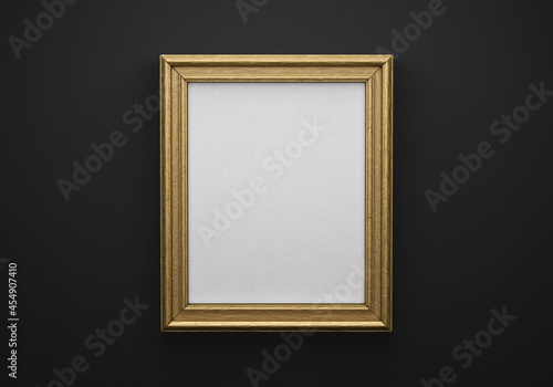 The bronze color picture vertical frame on black wall with textured blank canvas, 3D mockup