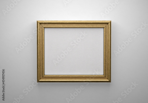 The bronze color picture horizontal frame on white wall with textured blank canvas, 3D mockup