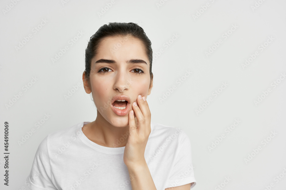 woman in white t-shirt holding face toothache discontent woman in white t-shirt holding face toothache discontent