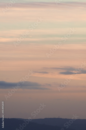 Vertical hazy sunset. Horizon under warm and faded pastel colours.