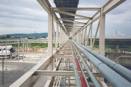 Fototapeta Steel long pipes rack work at high factory during refinery Petrochemistry indust