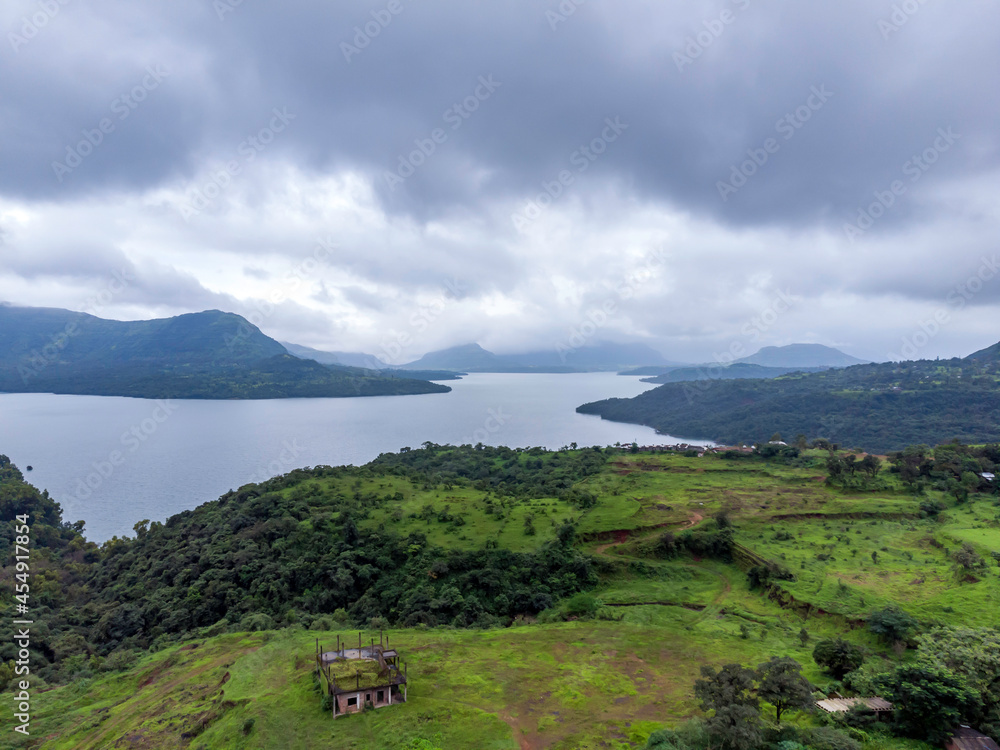 Aerial view of greenery, lake and clouds during the monsoon season at Mulshi near Pune India. Monsoon is the annual rainy season in India from June to September.