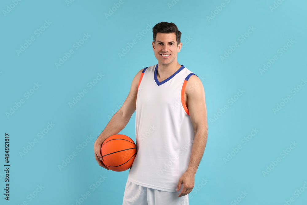 Basketball player with ball on light blue background