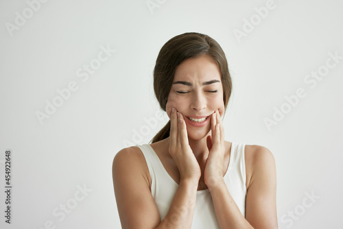 woman in white t-shirt teeth pain dentistry discomfort